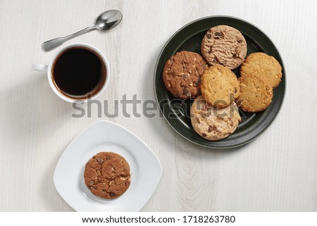 Various cookies with chocolate and nuts and cup of coffee on table, top view 
