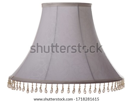 isolated close up shot of a classic cut corner bell shaped grey tapered lampshade with a beaded fringe on a white background