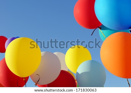 multicolored balloons in the city festival on blue sky background