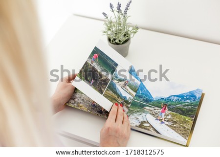 Young blond woman holding a photo album. photobook