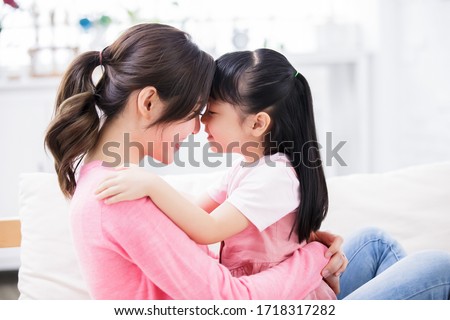 Mom hold daughter in her arm and child smile happily