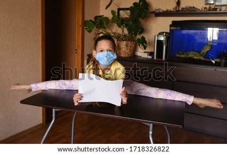 young woman doing yoga exercise. young woman holding blank sign. Coronavirus. children with face mask on quarantine, cooks in the kitchen at home during coronavirus crisis. Stay at home. Enjoy cooking