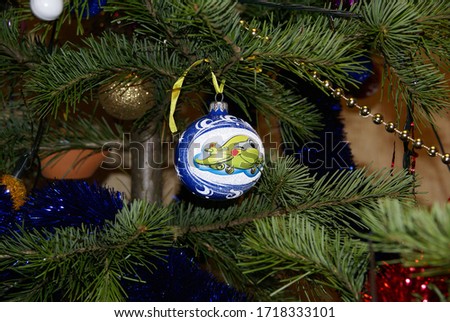 the Christmas Tree is decorated with toys including a shiny blue balloon with a picture of a green airplane