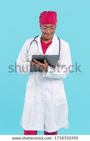 Female black doctor writing on clipboard 