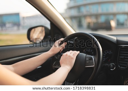 left Woman hand on a steering wheel and honking a horn with  her right hand. Royalty-Free Stock Photo #1718398831