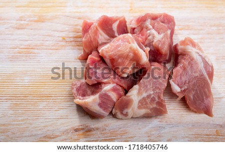 Close up of raw pork slices on wooden surface, nobody