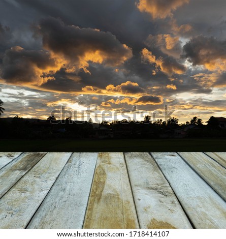 wood plank on sunset background, wood table board empty on orange sky sun sets over cloud dark, wood table board empty on gold sky sun lighten clouds evening sunset                               