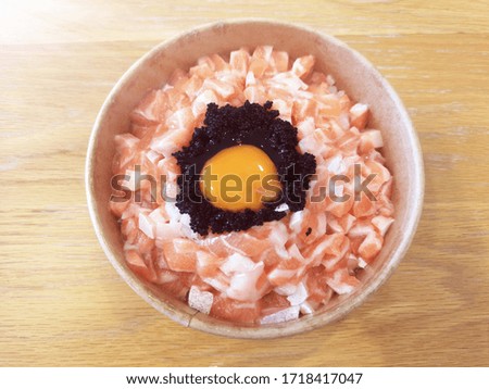 Closeup salmon with raw eggs donburi Japanese rice. 