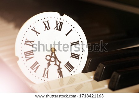 A clock with Roman numerals and a piano, retro