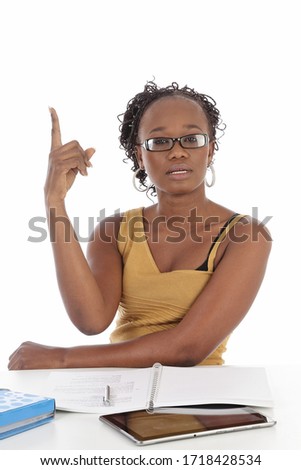
portrait pretty young black african american woman studying her lessons on a desk on white isolated studio background