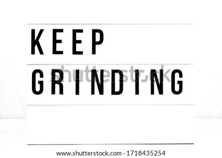 Inspirational Keep Grinding quote on vintage retro board. Concept. flat lay