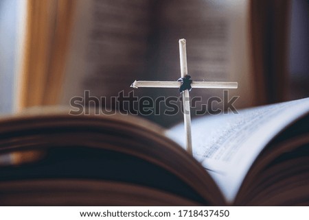 Open Holy Bible book and homemade cross, close-up view