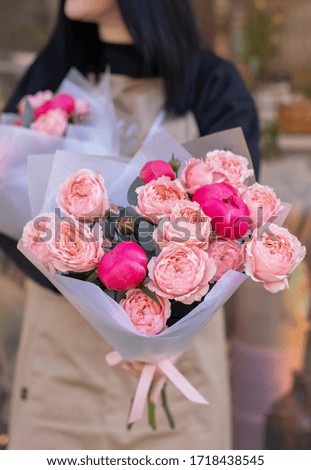 Fresh beautiful flower. Woman holding two flower bouquets of roses, peony and eucalyptus wrapped in white paper.