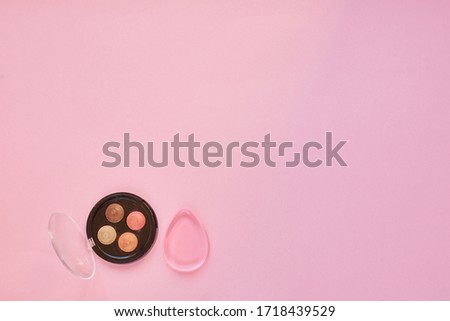 the concept of cosmetics and skin care, silicone sponge and eye shadow on a pink background