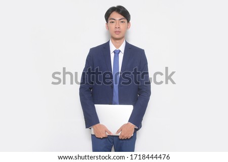 Young handsome businessman Holding a laptop Computer 

