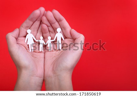 Paper Family in Hands over red background. Family and Kids Concept