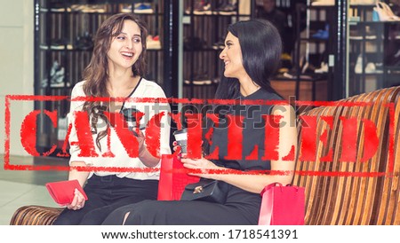 Word CANCELLED on background of two young women in the shopping mall. Coronavirus quarantine. Closed shopping mall.