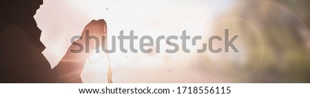 Silhouette Young muslim woman hijab honesty pray to God on sunset panoramic mosque background concept for eid mubarak, life and spiritual of islam girl fasting in ramadan, Indonesian civilian people Royalty-Free Stock Photo #1718556115