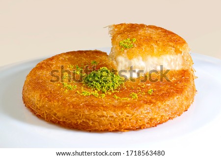 Turkish dessert kunefe, kunafa, kadayif with pistachio, walnut powder and cheese hot eaten a sweet Royalty-Free Stock Photo #1718563480