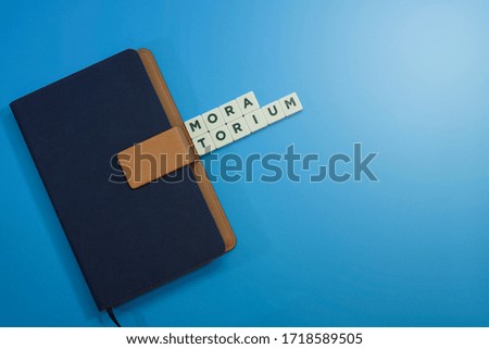 View of a note book with block lettering on blue background.  Business and banking finance concept