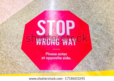 Red warning direction stop sign text for entering wrong way in store aisle during covid-19 coronavirus outbreak with nobody in USA