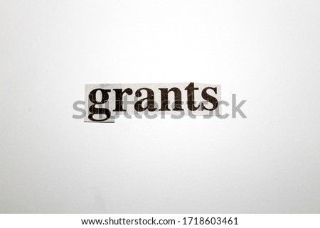 Cut out of white coloured piece of paper, with a print saying 'grants' in the midst of the Coronavirus pandemic. Shot in a studio, with a plain white background