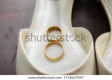 Wedding rings  with white shoes background Bride and Grooms gold wedding rings on natural Close up photo.