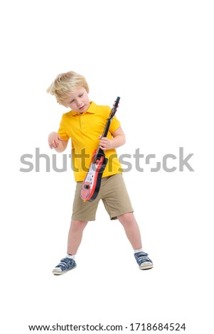 Boy plays on toy guitar isolated on white background