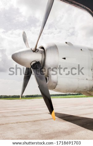 Propeller of an aircraft close-up. Airplane turboprop engine with wing and with 4 blade and with propeller, parts of aircraft fuselage on the cloudy sky and nature background. plane landed successfull
