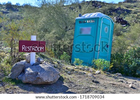 An amusing outdoor restroom sign in the middle of nowhere.