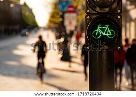 Sustainable transport. Bicycle traffic signal, green light, road bike, free bike zone or area, bike sharing with silhouette of cyclist and bike on the blurred background, bike-friendly Royalty-Free Stock Photo #1718720434