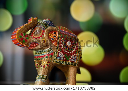 Colorful indian elephant sculpture on wood with bokeh background