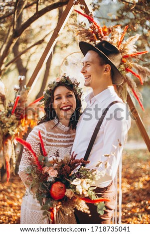 Bride and Stylish Groom. Happy wedding couple at a wedding ceremony outdoors in the park during sunset. Atmospheric glow of the sun and beautiful lovers - Perfect Wedding background