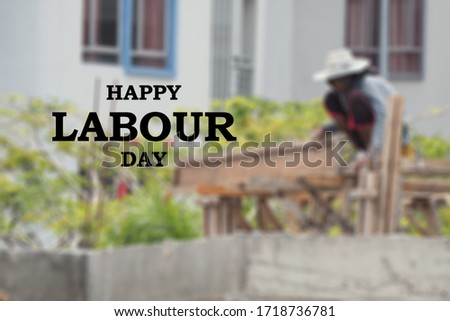 Happy Labour Day. Construction workers working on the blurred background.