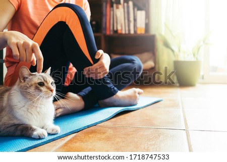 woman doing yoga at home with her cat. Copyspace background