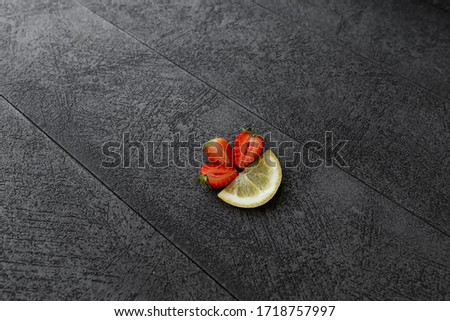 strawberries and lemon on a black background