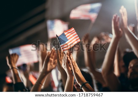 Soccer supporters with USA flags cheering on team success. Group of football fans celebrating victory. Royalty-Free Stock Photo #1718759467
