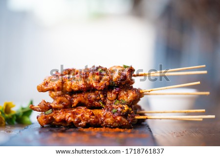 Top view of grilled pork stick image with spicy sichuan pepper sauce.Very hot and spicy taste - Local Thai street food and spicy food style.Picture for appetizer menu.Delicious food in Thailand.