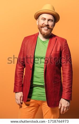 A portrait of a bright man posing in the studio over the yellow background. Men, beauty, colors, fashion.