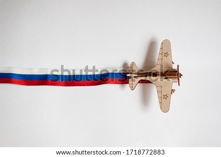 plane with the Russian flag. The background for the cards to win the Day. Background for congratulations on may 9. Wooden plane with a ribbon of the colors of the Russian flag. Children's toy plane fo Royalty-Free Stock Photo #1718772883