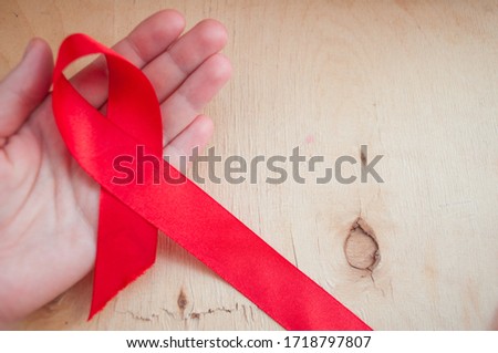 hand holds red awareness ribbon, world aids day, aids awareness ribbon. Royalty-Free Stock Photo #1718797807