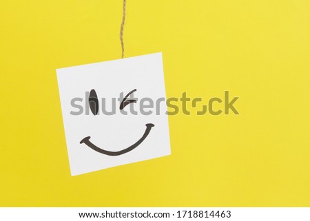 A painted smiley on a white sheet . Positive thinking concept. hiding some bad feeling just keep smiling