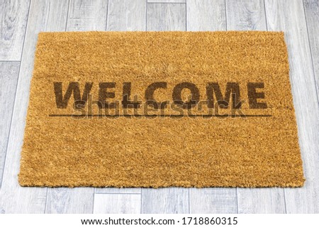 Welcome door mat on grey vinyl floor