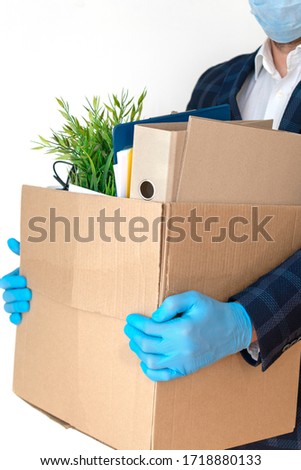 Dismissal employee in an epidemic coronavirus. Dismissed worker going from the office with his office supplies. Isolated on a white background. Vertical photo.