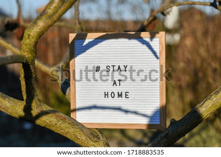 Stay at home' words on lightbox, in the garden outdoors, Safety concept.