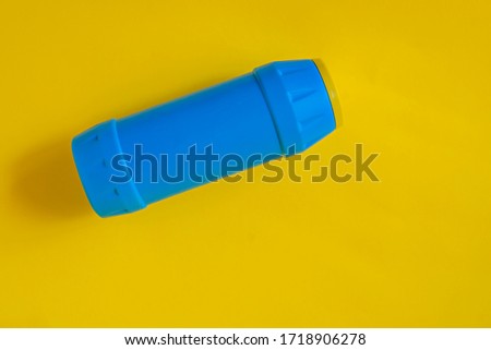 Plastic blue bottle on yellow font. Plastics for chemistry and cleaning agents. Plastic container.