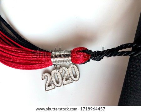 Black and red 2020 graduation tassel on a white background