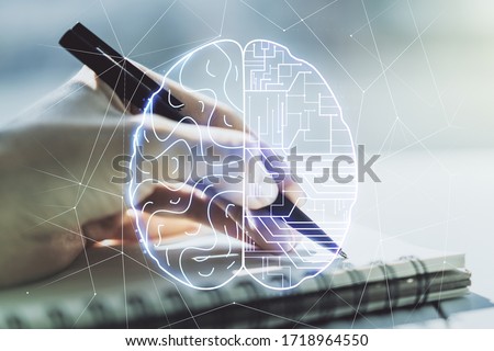 Creative artificial Intelligence concept with human brain hologram and woman hand writing in notebook on background. Multiexposure