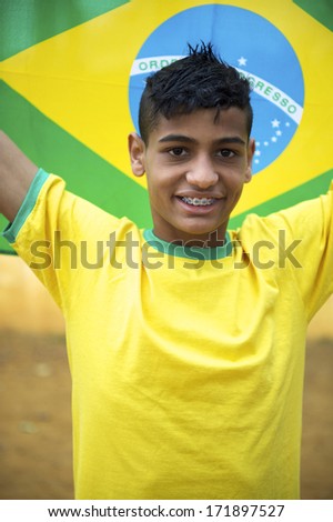 Proud patriotic young Brazilian football fan wearing national colors holding up a Brazilian flag