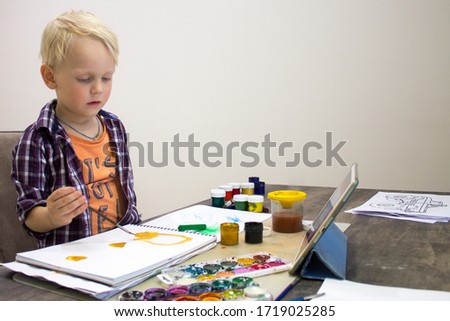 Creative toddler boy is creativity and the artist in an online drawing paints lesson. Childrens creativity. The concept of distance learning online school for the period of global quarantine.